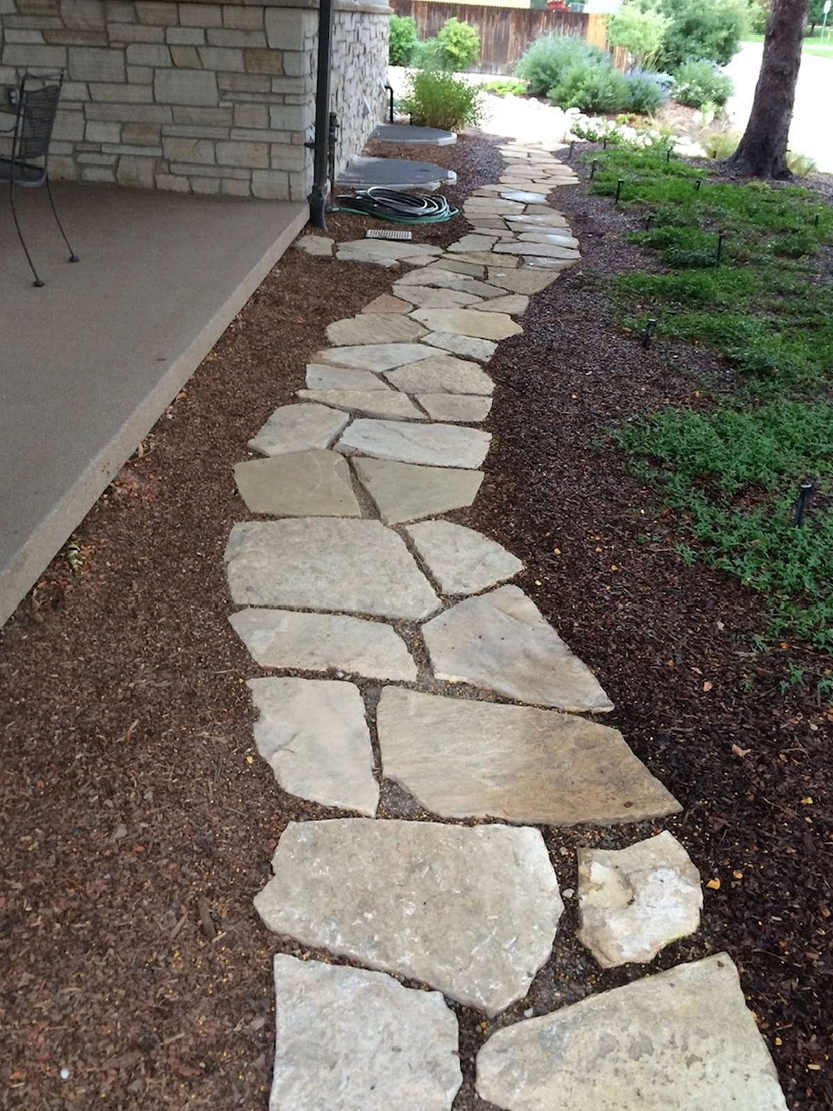 Side-yard path — Flagstone path with a red mulch bed