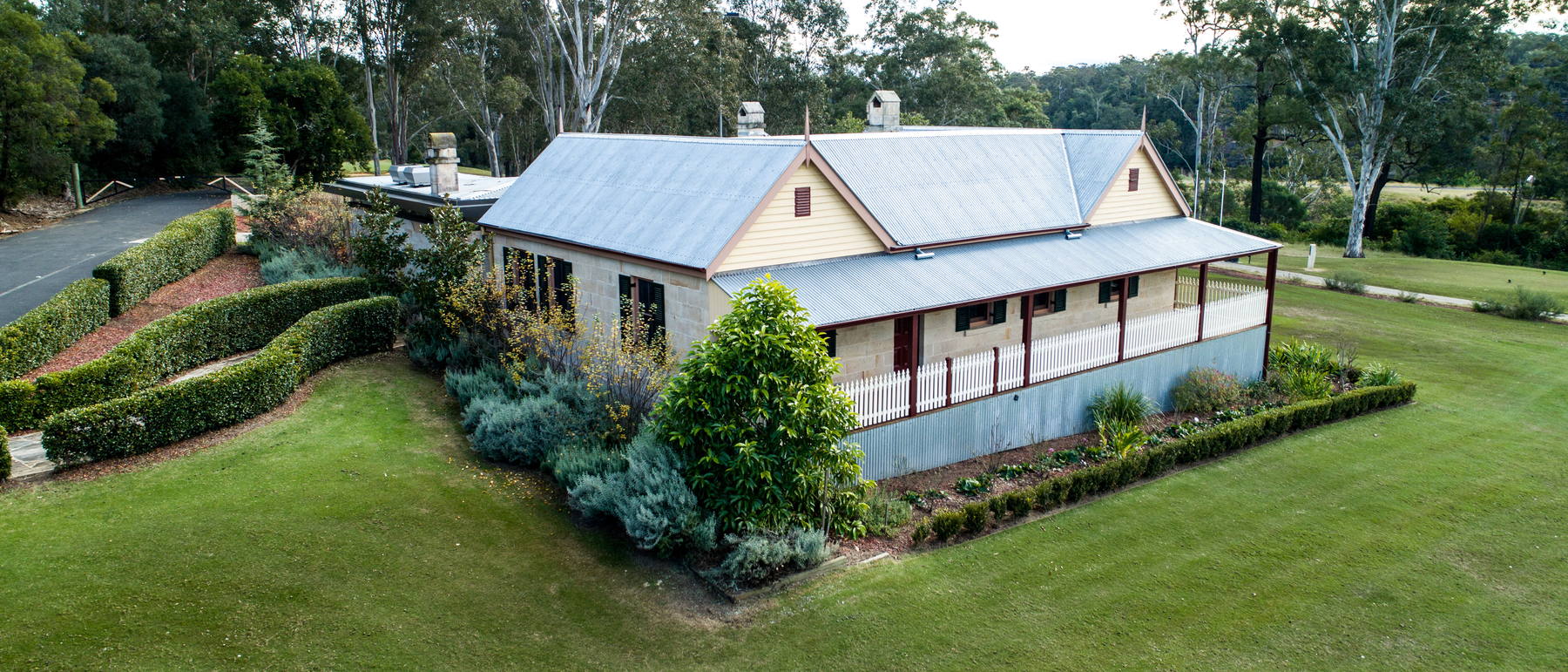 A house behind a terraced retaining wall and planted beds